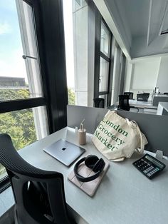 a bag sitting on top of a white table next to a laptop computer and calculator