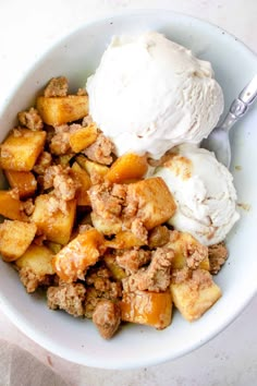 a white bowl filled with ice cream and some type of fruit salad on top of a table