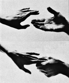 hands reaching out to each other in black and white