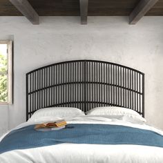 a bed with a book on top of it in a room that has white walls