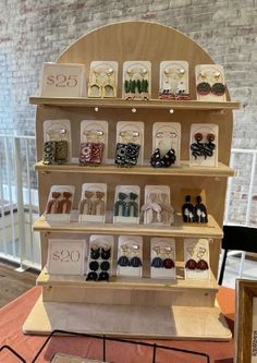 a display case with many different types of earrings on it's shelves in a store