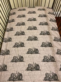 a crib bed with a tractor print on it