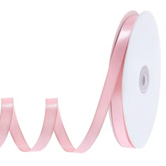 a roll of pink satin ribbon on a white background