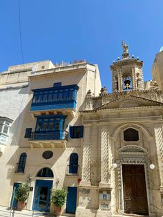 an old building with blue shutters and windows