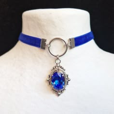 Choker necklace, Victorian style velvet choker with a beautiful sapphire blue crystal. -------------- Details ---------------- - Real oval faceted cut crystal: 13x18mm - Intense and vibrant color: sapphire blue - Victorian pendant set with claws in antique silver-colored brass: 45x25mm - Choker in matching blue velvet and stainless steel findings: 31-39cm with the extension to adjust to your convenience (contact me for another length) - Several colors available -------------- Delivery ---------- Choker With Pendant, Fantasy Choker, Blue Crystal Jewelry, Blue Wedding Accessories, Accessories Blue, Dark Blue Jewelry, Royal Blue Jewelry, Blue Choker Necklace, Blue Pendant Necklace