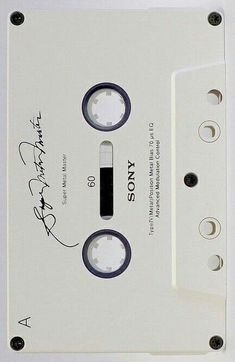 an old white cassette with writing on the side and two black buttons in front of it