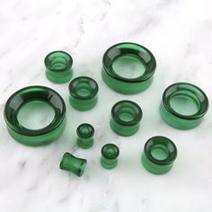 several green glass pieces on a marble surface