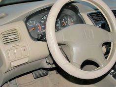 the interior of a car with steering wheel and dash board, including gauges and dashboard controls