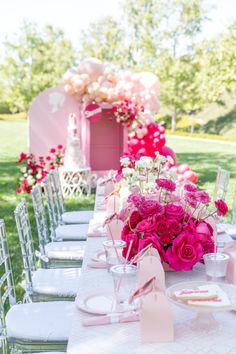 the table is set with pink and white flowers