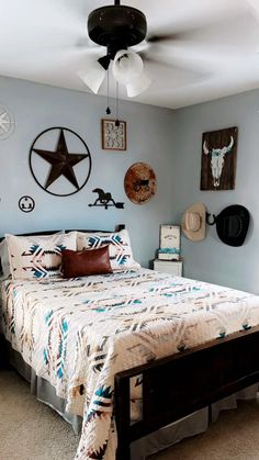 a bedroom with a bed, ceiling fan and pictures on the wall above it's headboard