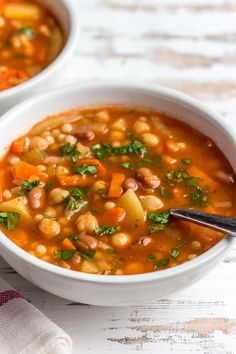 two white bowls filled with bean and vegetable soup