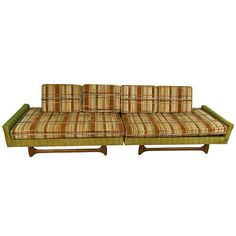 a set of three couches with plaid upholstered cushions and wooden legs,