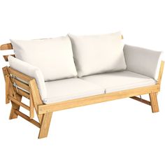 a white couch with two pillows on it's back and arm rests against a wooden frame