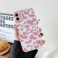 a person holding up a phone case with pink and white leopard print on the back