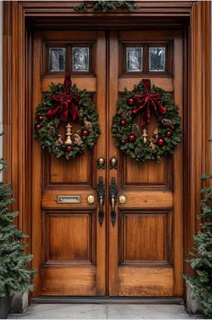 two christmas wreaths are hanging on the front door