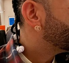 a man with dreadlocks wearing a heart shaped earring