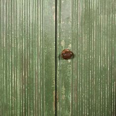 an old green door with a rusted knob on it's front and side