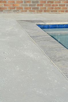 a fire hydrant sitting on the side of a pool next to a brick wall