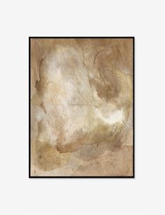 an abstract painting with white and brown colors in a black frame on a beige wall