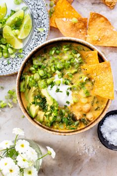 a bowl filled with tortilla soup and topped with sour cream, avocado chips