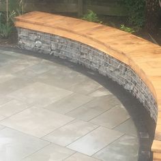 a wooden bench sitting on top of a stone patio