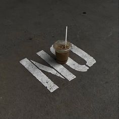 an iced drink sitting on the ground with a straw in it