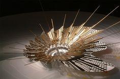 a large metal object on top of a white table with lots of sticks sticking out of it