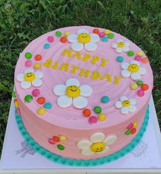 a pink birthday cake sitting on top of a table