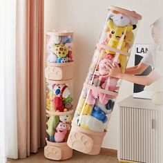 a child's toy storage rack with stuffed animals in it and two children's toys stacked on top