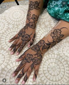 a woman's hands with hennap and flowers on them