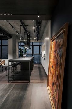 an open kitchen and dining room area in a modern home with wood floors, black walls, and large windows