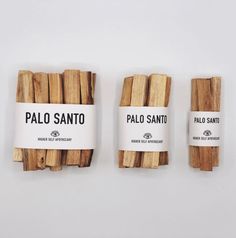 three pieces of palo santao are lined up on a white surface, with labels attached to them