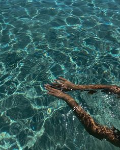 a person floating in the water with their arms outstretched