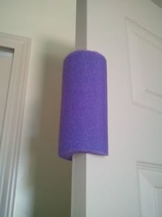 a purple lamp hanging from the side of a white wall next to a door with an instagram button on it