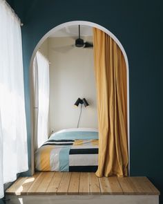 a bed sitting under an arch next to a window