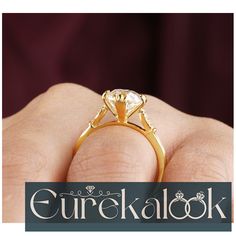 a close up of a person's hand holding a ring with a diamond on it