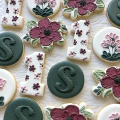 decorated cookies with the letter s and flowers on them are laid out in order to be eaten