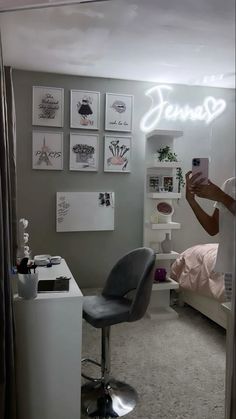 a woman taking a selfie in her bedroom with the word jenny written on the wall