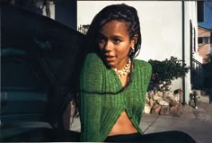 a woman sitting on the ground next to a car