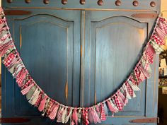 a red and white checkered bunting is hanging from the side of a blue cabinet