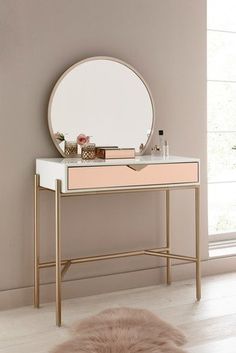 a vanity table with a mirror and a fur rug on the floor in front of it