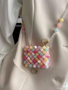 a close up of a white jacket with buttons and beads on the back of it