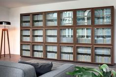 a living room filled with furniture and lots of bookshelves on the wall next to a lamp