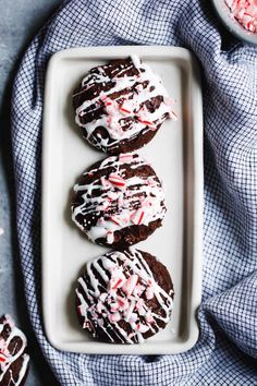 chocolate peppermint cookies with white frosting and sprinkles on a plate