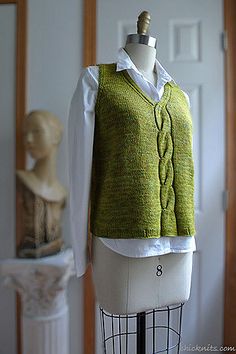 a mannequin wearing a green sweater and white shirt