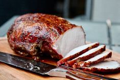 a piece of meat on a cutting board next to a knife