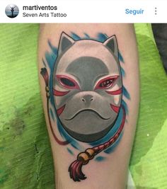 a person with a tattoo on their leg that has an image of a cat wearing a mask