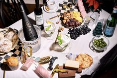 a table topped with lots of different types of food and bottles of wine on top of it