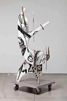 a white sculpture with black and white designs on it's body sitting on a cart