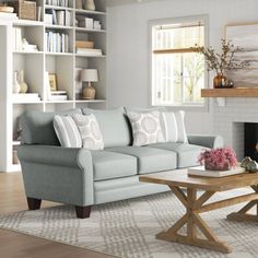 a living room filled with furniture and a fire place in front of a white fireplace